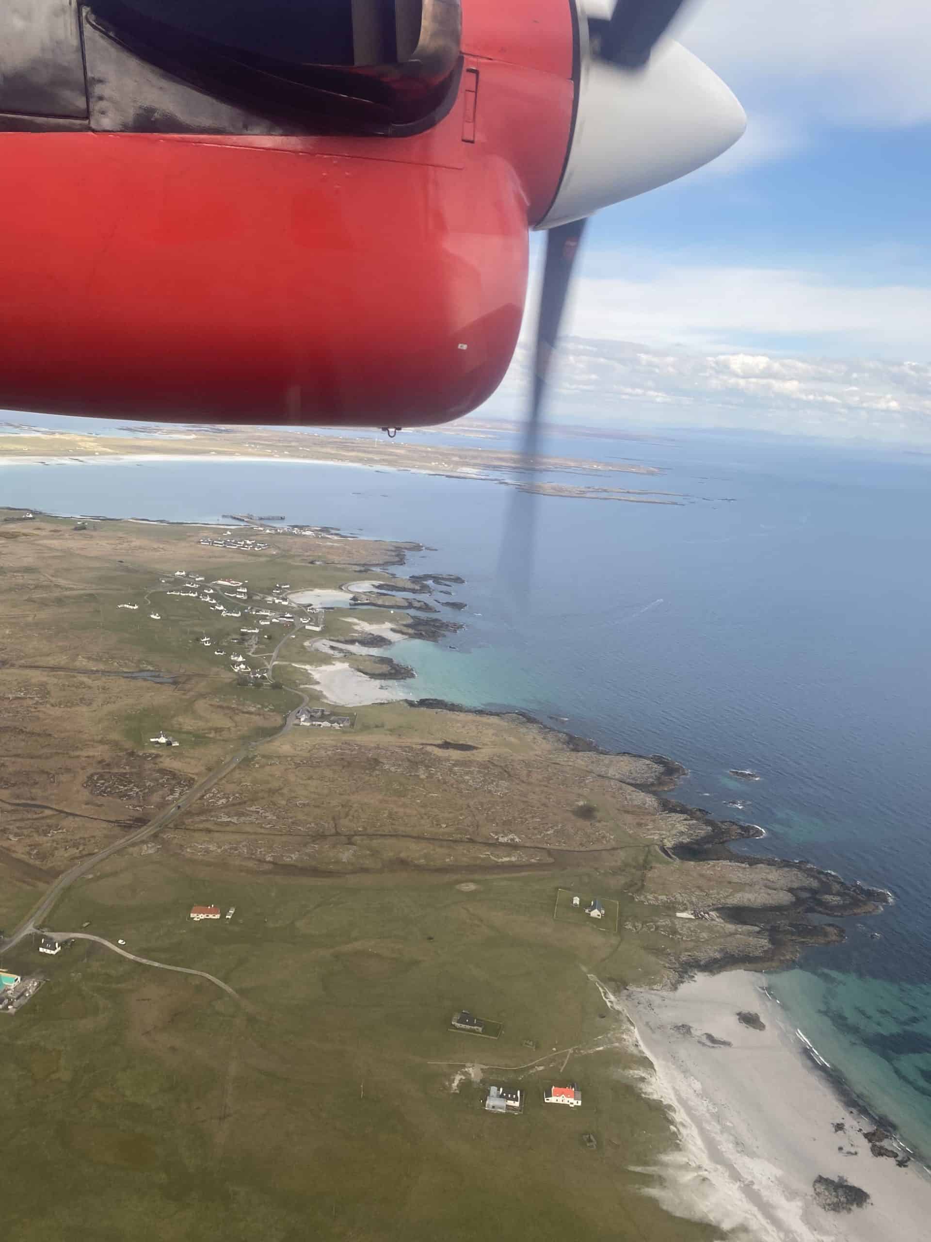 Stunning aerial view of coastline from small aircraft wing during flight over ocean and land.
