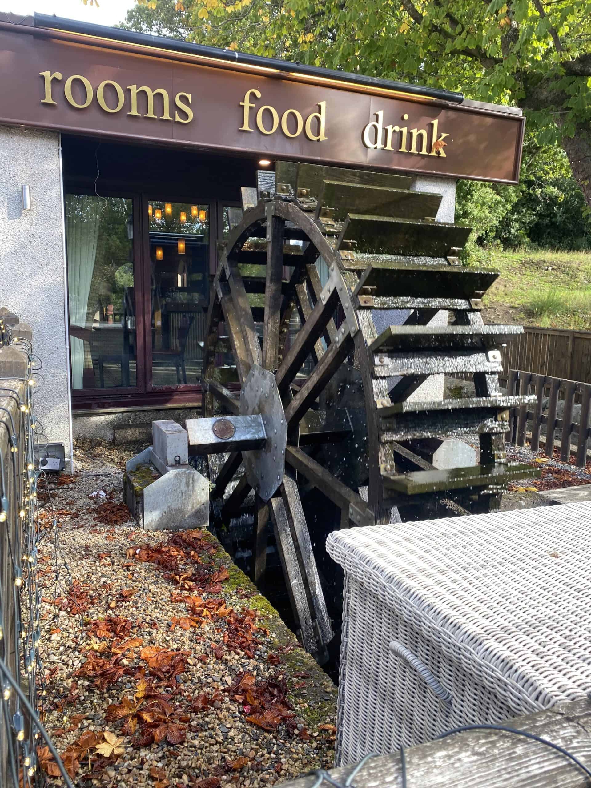 Water wheel outside a cafe with food, drinks, and rooms at Wee Trails, outdoor scenery, autumn.